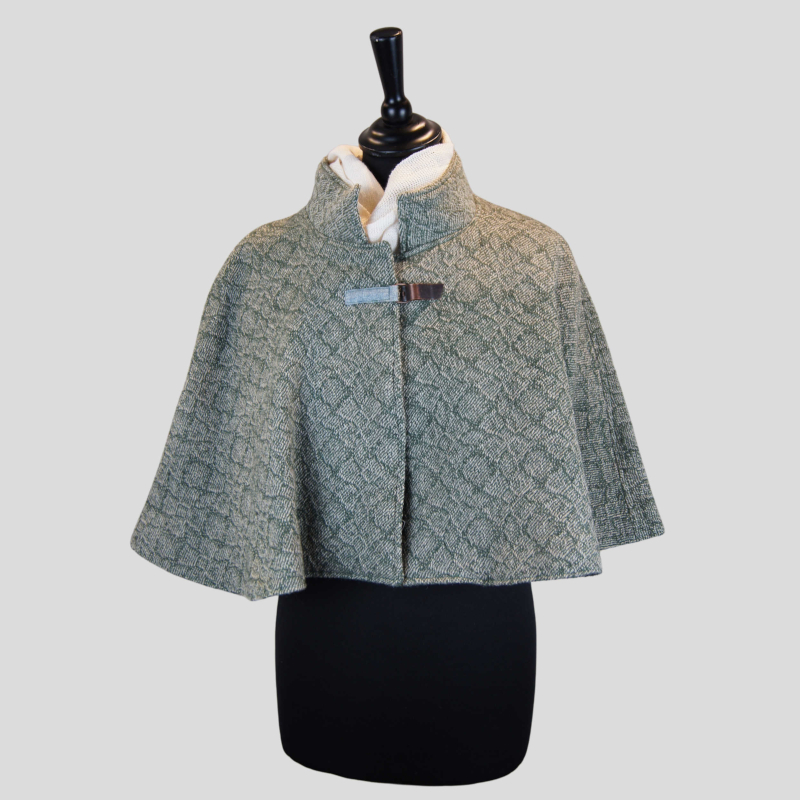 Cape courte vert lichen pour femme, présentée sur un buste mannequin, tissage artisanal